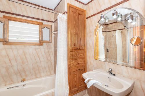 a bathroom with a sink and a tub and a mirror at Front Line Beach House Up To 6 Guests in Mallorca in Son Serra de Marina