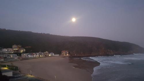 a view of a beach with the moon in the sky at Apartment Ozone in Herolds Bay