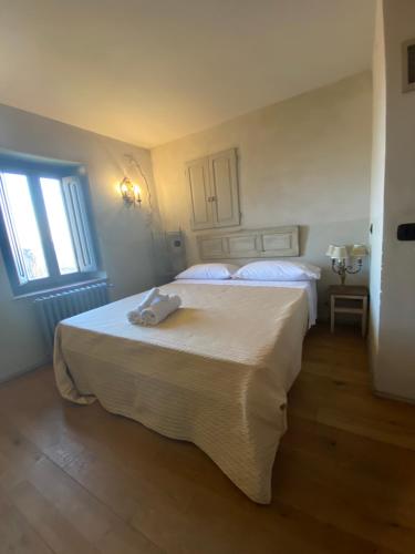 a white bedroom with two beds and a window at Residenza Buggiano Antica B&B - Charme Apartment in Tuscany in Borgo a Buggiano
