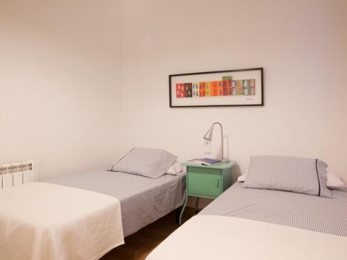 ein Schlafzimmer mit 2 Betten und einem Tisch mit einer Lampe in der Unterkunft Sagrada Familia in Barcelona