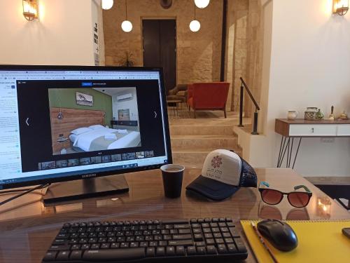 a computer monitor on a desk with a keyboard and a mouse at The Negev Hotel By Domus in Beer Sheva