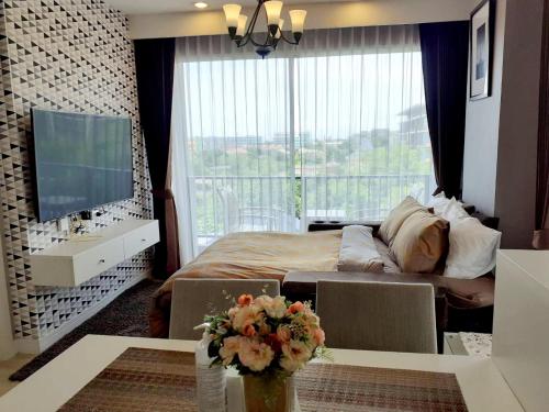 1 dormitorio con cama y ventana grande en Execlusive Seaview 1 bedroom suite with toproof pool at The Patio Bangsaen en Bangsaen Sai 1