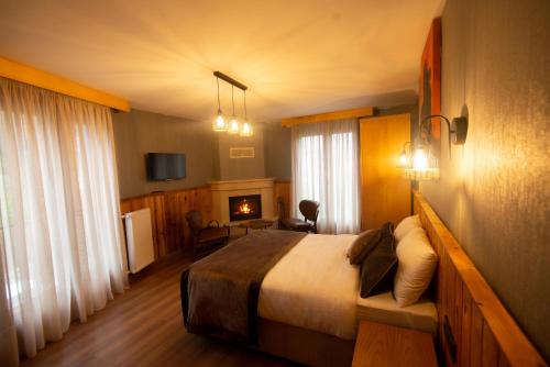 a hotel room with a bed and a fireplace at Ayder Koru Hotel in Ayder Yaylasi