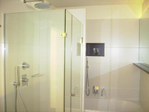 a shower with a glass door in a bathroom at Appartements Christa in Dobbiaco