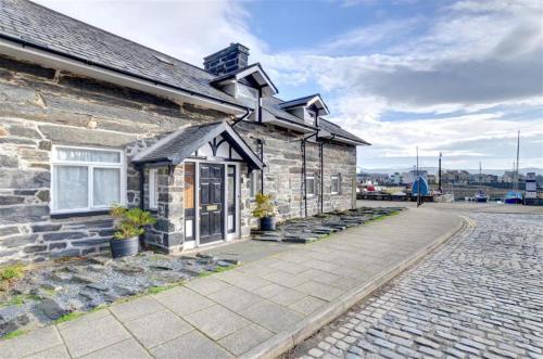 a stone house with a stone walkway in front of it at Greaves Wharf House in Porthmadog