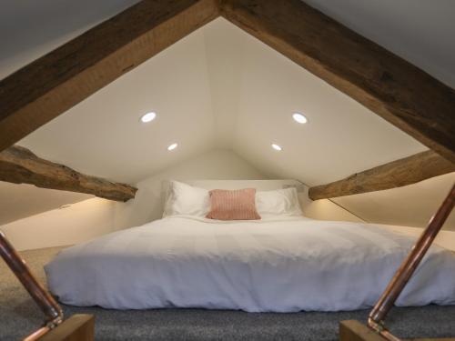 a bedroom with a white bed in an attic at Glan Meon Cottage in Barmouth