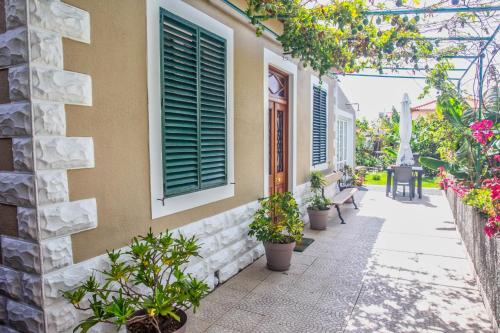 a walkway with plants and a building with a window at Casa da Bungavillia in Machico