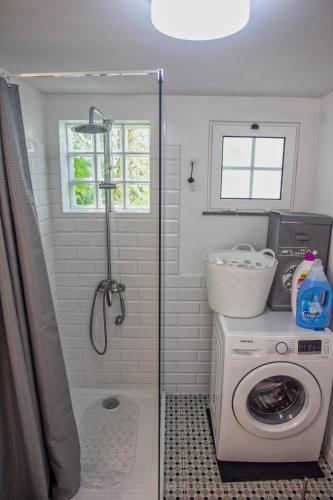 a bathroom with a washing machine and a washer at Casa da Bungavillia in Machico