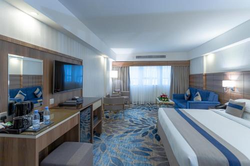 Una habitación de hotel con una cama grande y un televisor. en Season Star Hotel Madinah, en Medina