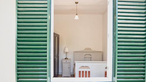 a view of a room with green shutters at Casa da Bungavillia in Machico
