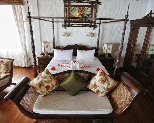 a bedroom with a bed with pillows on it at La Digue Emerald Villa in La Digue
