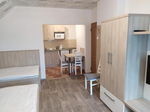 a room with a bed and a kitchen with a table at Apartmány Okoun in Velké Losiny