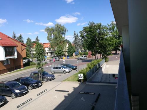 a view of a street with cars parked in a parking lot at Centro apartamentai in Birštonas
