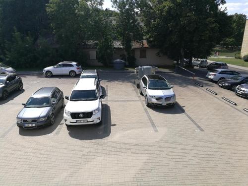 a group of cars parked in a parking lot at Centro apartamentai in Birštonas
