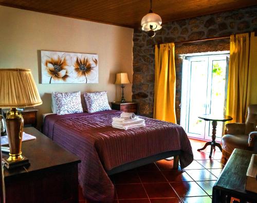 a bedroom with a large bed and a window at CASA DO CASTELLO MONSANTO in Monsanto