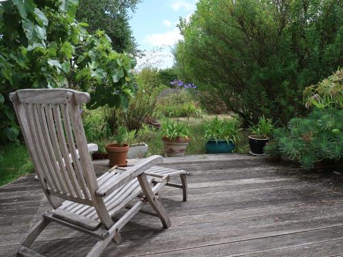 a wooden rocking chair sitting on a wooden deck at Holiday Home Pavillon Asiatique by Interhome in Loctudy