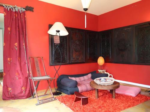 a red living room with a couch and a table at Holiday Home Pavillon Asiatique by Interhome in Loctudy