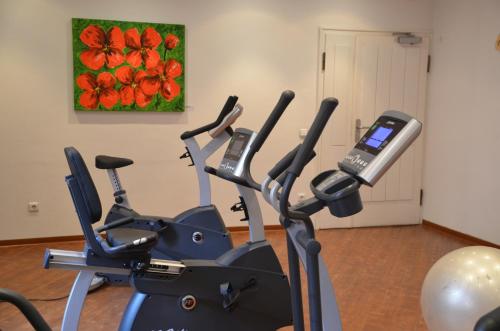 a gym with a cell phone on a exercise bike at Hotel Amba in Munich