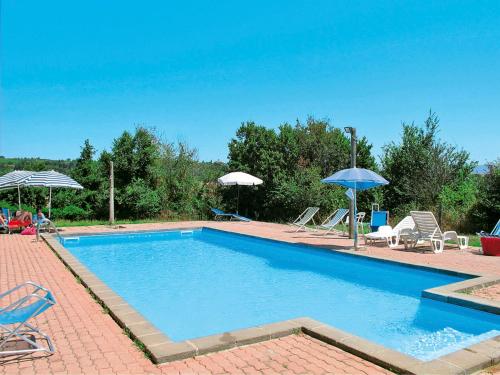 a large swimming pool with chairs and umbrellas at Holiday Home Topano by Interhome in Pianucciole