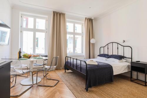a bedroom with a bed and a table and chairs at Apartment Copernicus No. 25 in Toruń