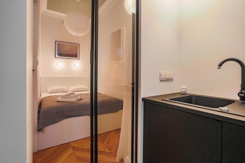 a kitchen with a sink and a bed in a room at Apartment Copernicus No. 25 in Toruń