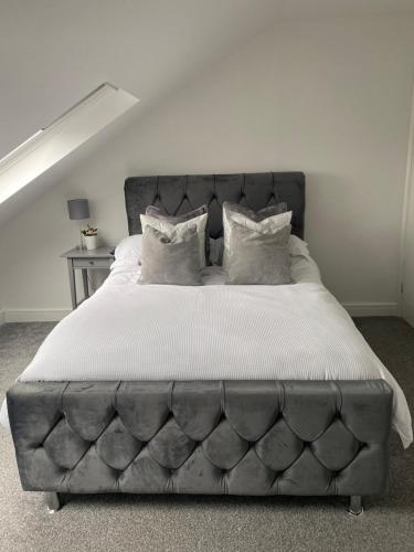 a large bed with a tufted headboard in a bedroom at Coalhouse Apartment in Seaham