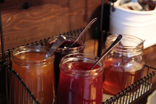 uma bandeja com quatro potes de vidro cheios de mel em Chamanna Bed & Breakfast em Arosa