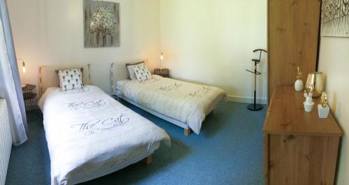 a bedroom with two beds and a table and a desk at La Maison du Lac in Lignan-de-Bordeaux