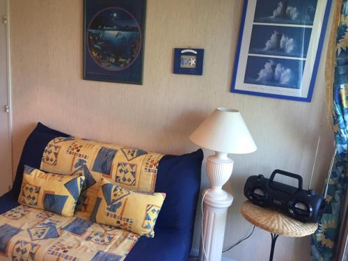 ヴィレ・シュル・メールにあるDeauville Plage 1の青いソファ、枕、ランプが備わる客室です。
