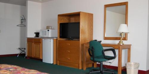 una camera da letto con scrivania, sedia e TV di Country Haven Inn a Hillsboro
