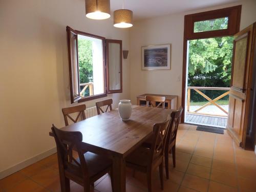 a dining room with a wooden table and chairs at La Maison du Lac in Lignan-de-Bordeaux