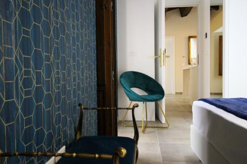 a bedroom with a blue chair and a bed at Nel Cuore dell'Aquila BnB in LʼAquila