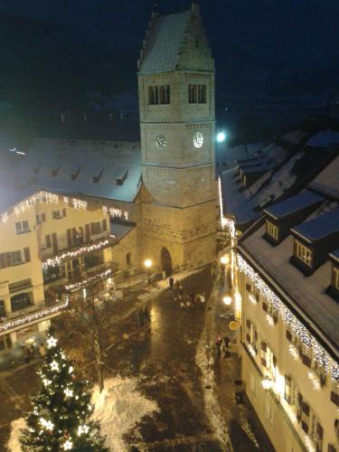 a building with a clock tower in a town at night at Gartenapartment in Zell am See