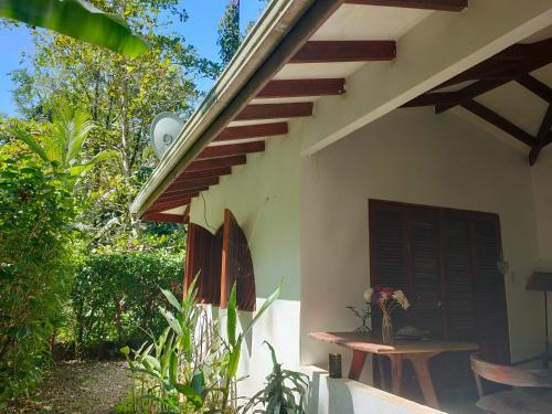 a porch of a house with a table and stairs at Finca Ardilla Jungle Lodge in Cocles