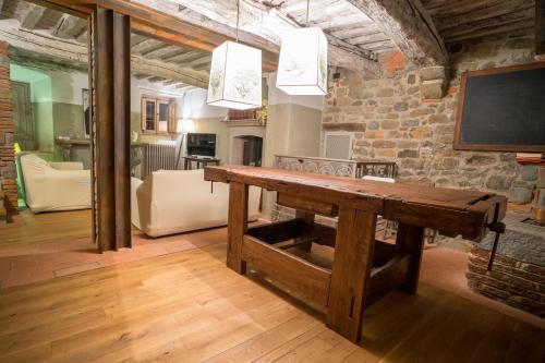a wooden table in a room with a stone wall at Hotel Villa Sermolli in Borgo a Buggiano