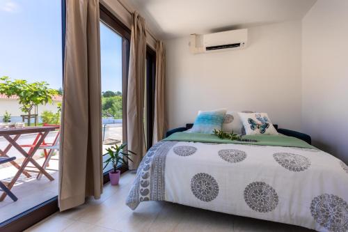 a bedroom with a bed and a balcony at VSG Resort - Apartments 200m from Beach, Pool, Sauna & Jacuzzi in Klimno