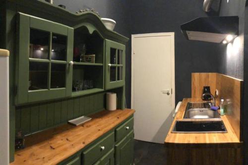 een keuken met groene kasten en een wastafel bij 2 room apartment in the Heart of Old Riga in Rīga