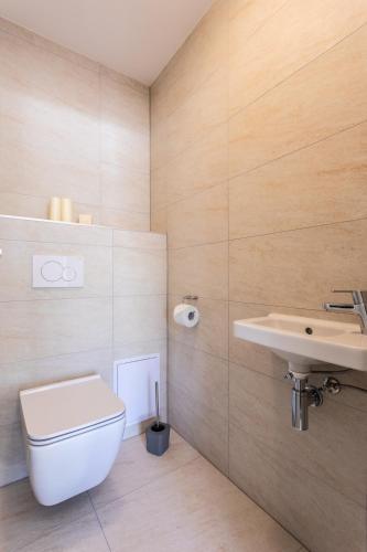 a bathroom with a toilet and a sink at VSG Resort - Apartments 200m from Beach, Pool, Sauna & Jacuzzi in Klimno