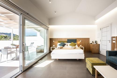 een slaapkamer met een bed en een balkon bij Montepetrosu Charming House in Monte Petrosu