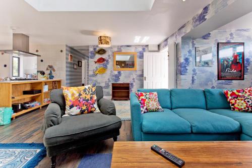 a living room with a blue couch and a chair at Big Sky in Camber