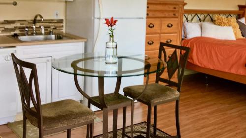 朱諾的住宿－Kelli Creek Cottage - REDUCED PRICE ON TOURS，一张玻璃桌,上面有两把椅子,一个花瓶