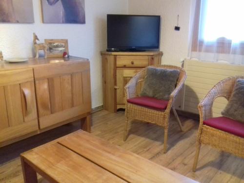 - un salon avec deux chaises et une télévision dans l'établissement 2 Alpes-locations Studio 4 personnes, à Les Deux Alpes