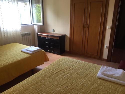 1 Schlafzimmer mit 2 Betten, einer Kommode und einem Fenster in der Unterkunft CASINA MERI in Pisones