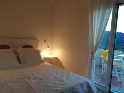 Schlafzimmer mit einem Bett und einer Glasschiebetür in der Unterkunft Home 4you in Karlovasi