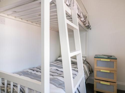a bunk bed with a ladder in a bedroom at Nasturtium Cottage in Par
