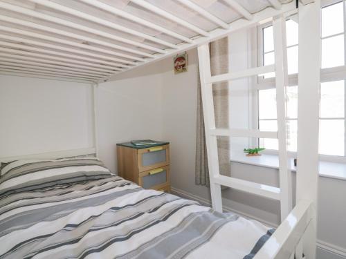 ein kleines Schlafzimmer mit einem Bett und einem Fenster in der Unterkunft Nasturtium Cottage in Par
