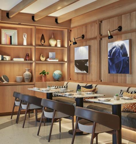 a restaurant with wooden walls and tables and chairs at Viceroy Santa Monica in Los Angeles