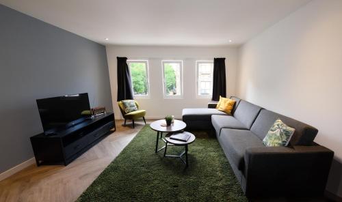 a living room with a couch and a tv at Spacious 65m2 Apartment in the Centre of Eindhoven - R65B in Eindhoven