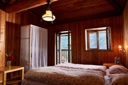 a bedroom with a bed and two windows in a room at Wild Valley Romantic Escape in Crana