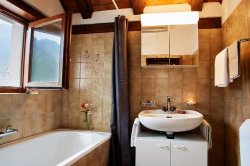 een badkamer met een wastafel, een bad en een spiegel bij Wild Valley Romantic Escape in Crana